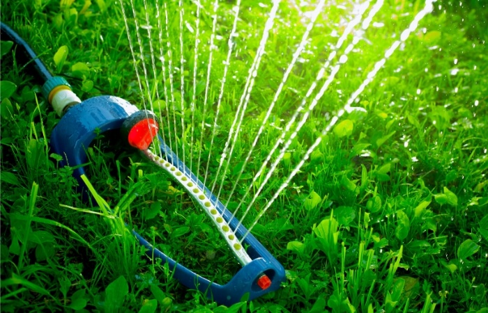 oscillating lawn sprinkler watering grass