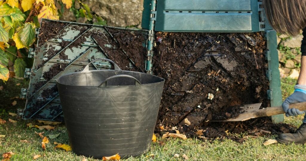removing finished compost with shovel